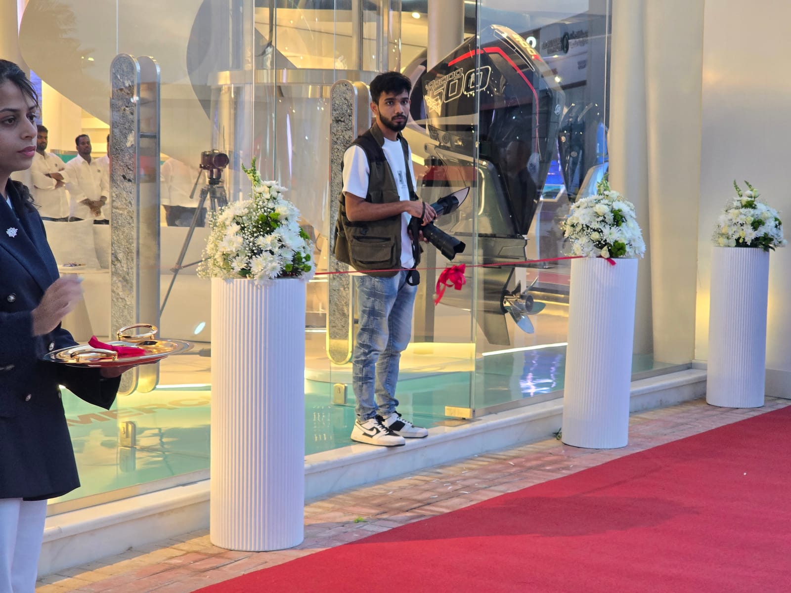 مدخل المعرض بالتنسيقات الزهرية والسجادة الحمراء