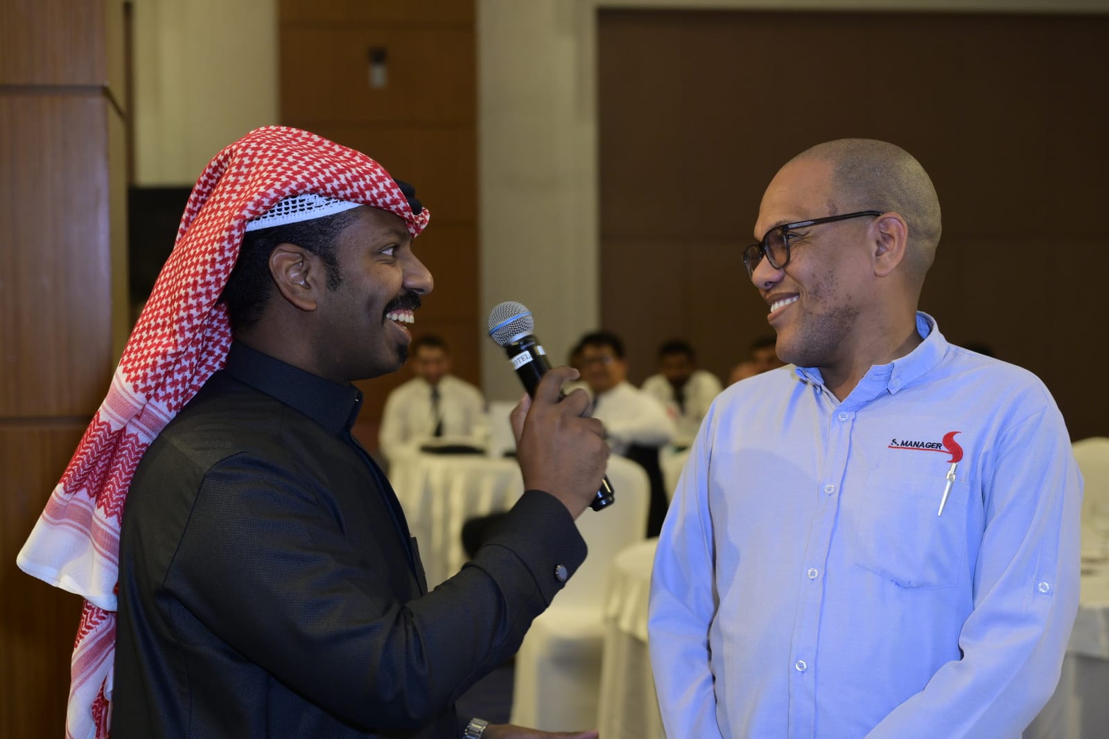 مقدم الفعالية يُفاعل موظفي التميمي خلال جلسة المسابقة