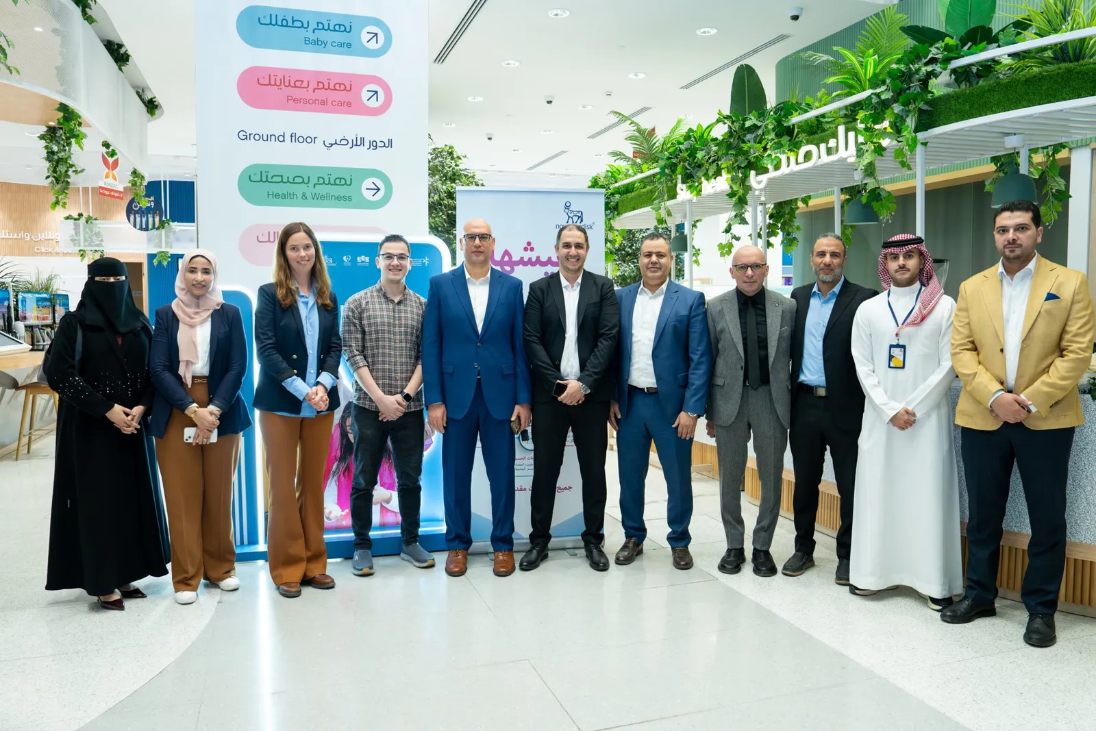 Full group photo of about 14 attendees in pharmacy atrium